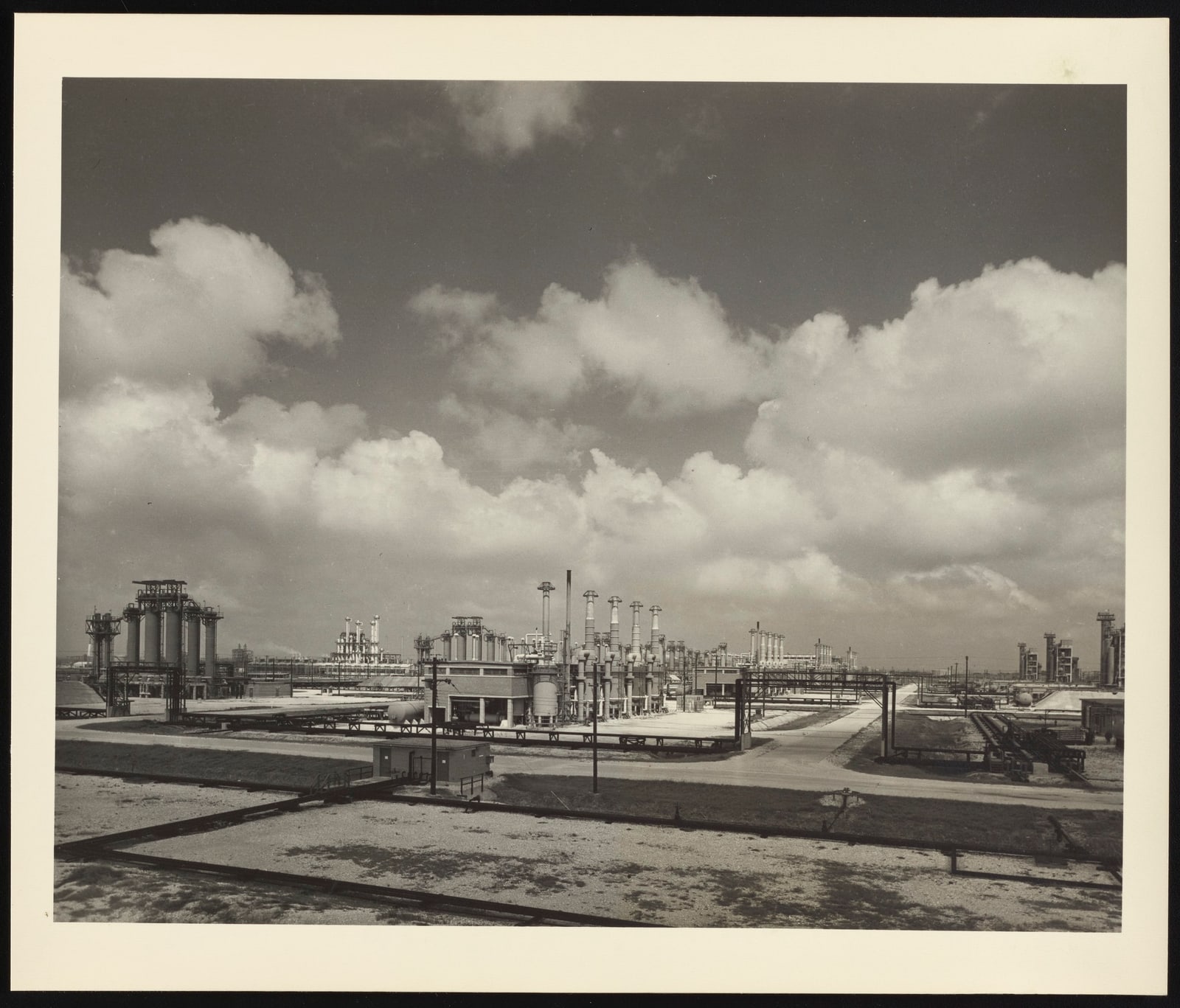 Black-and-white panoramic view of Dow Chemical's Freeport plant, with processing towers, storage tanks, and pipe racks.