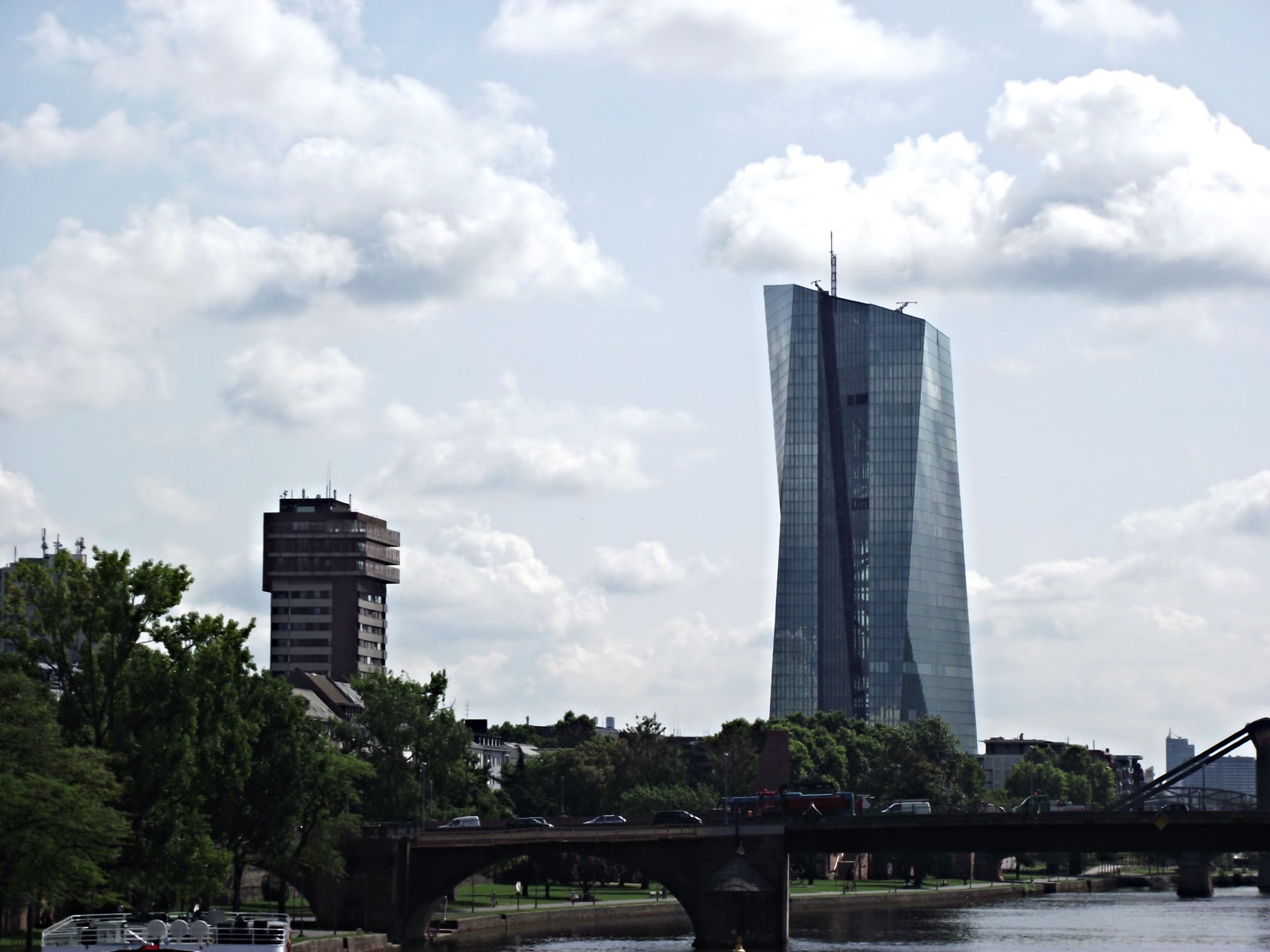 The European Central Bank's glass headquarters rising above trees in Frankfurt.