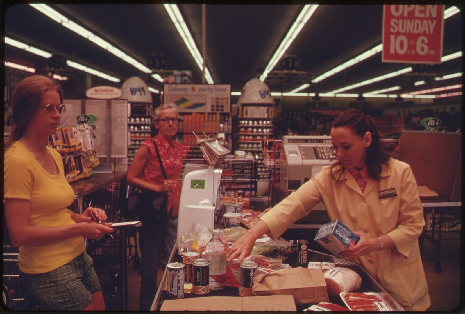 Shoppers and a cashier at a busy supermarket checkout in Washington, D.C., in July 1974.