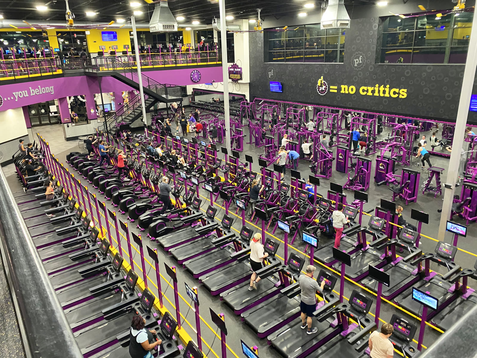 Rows of purple exercise machines and members fill a Planet Fitness club in Cincinnati, viewed from an upper level.