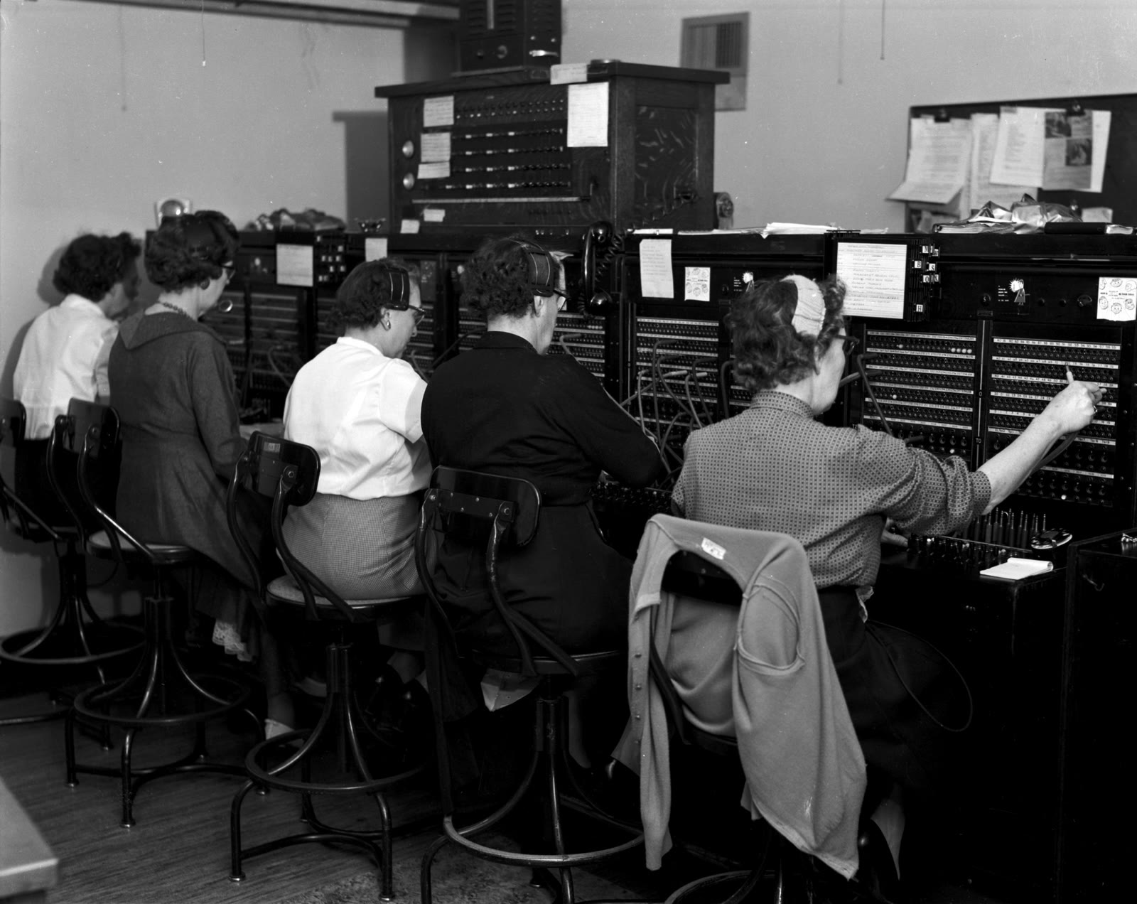Five telephone operators work a bank of manual switchboards in Seattle in 1958.