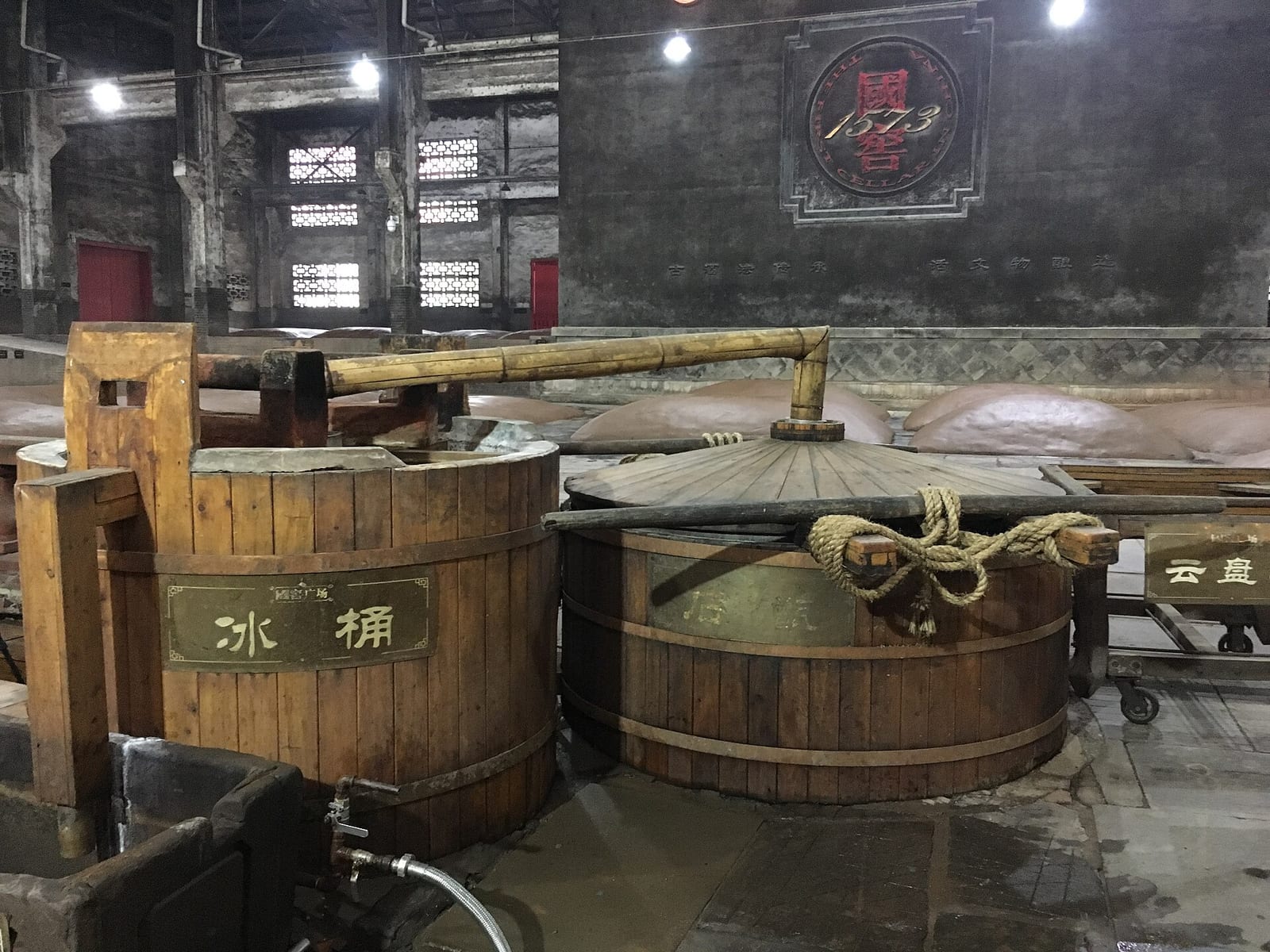Wooden tubs and a traditional bamboo-piped distillation apparatus inside the Luzhou Laojiao distillery in Sichuan.
