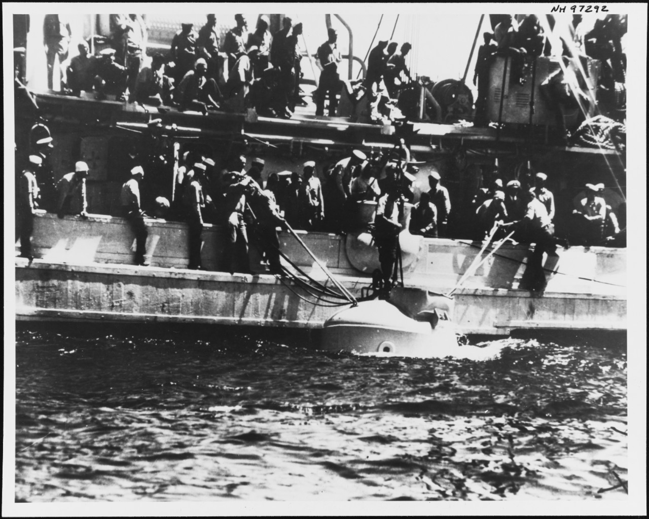 一张黑白档案照片：营救 USS Squalus 号期间，麦坎救援舱漂浮在 USS Falcon 号旁。