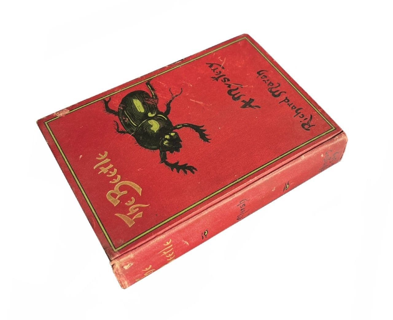 理查德·马什《甲虫》红布初版本的实拍照片，烫金书名下压印着黑绿两色昆虫。