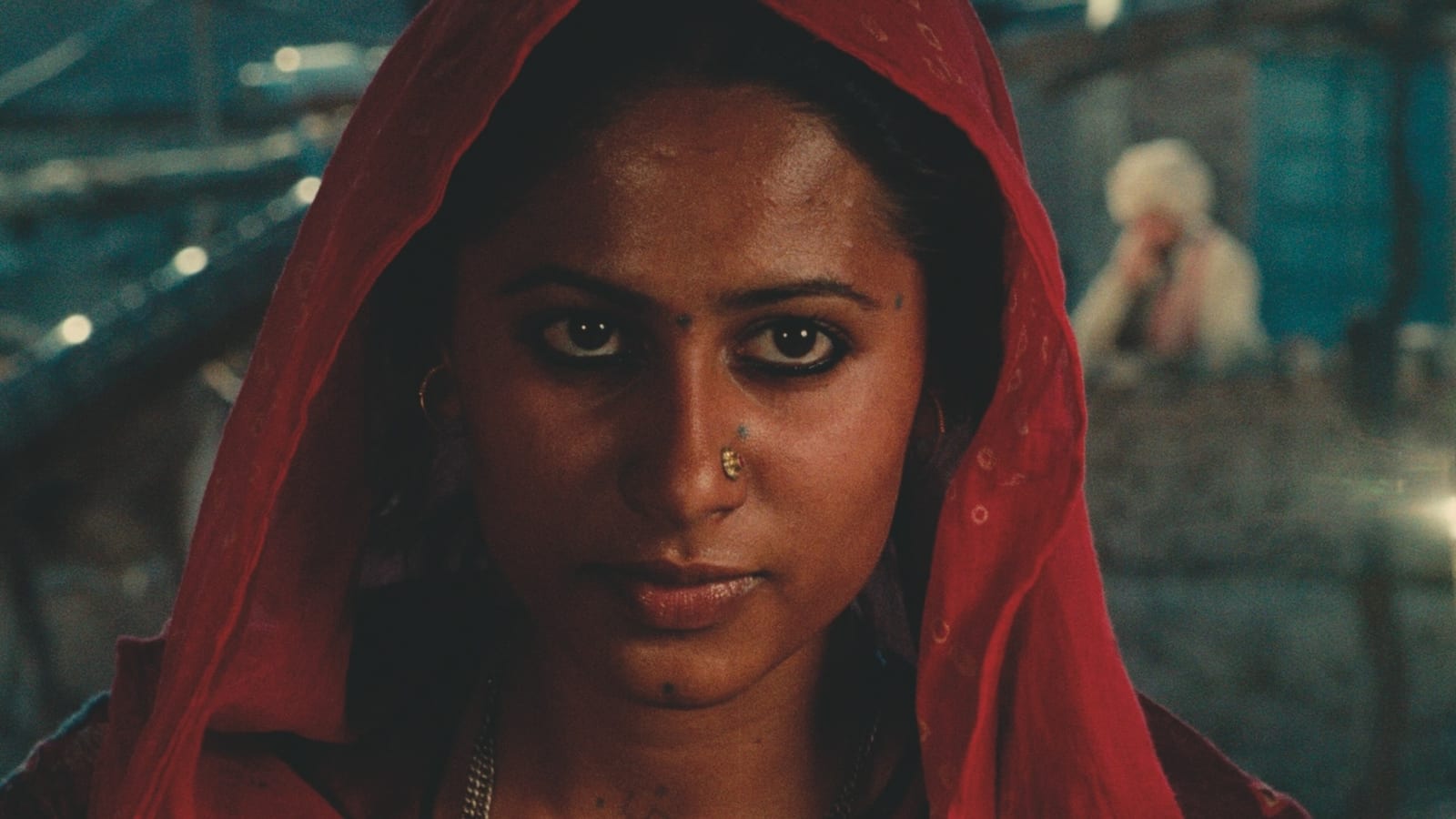 Smita Patil as Bindu looks directly toward the camera beneath a red head covering in a close-up from Manthan.