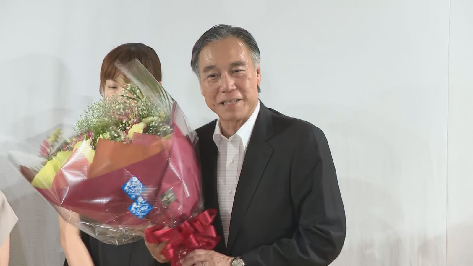 Nagano Governor Shuichi Abe holds a bouquet after winning a fifth term.