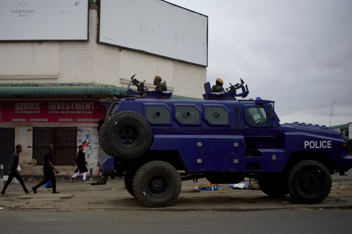 An armored police vehicle carrying officers parked on a sidewalk in Lusaka during Zambia’s interrupted election count.