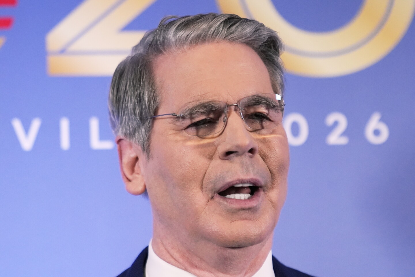 美国财政部长斯科特·贝森特出席阿什维尔 G20 财长会议，身后是蓝色 G20 2026 背景板。