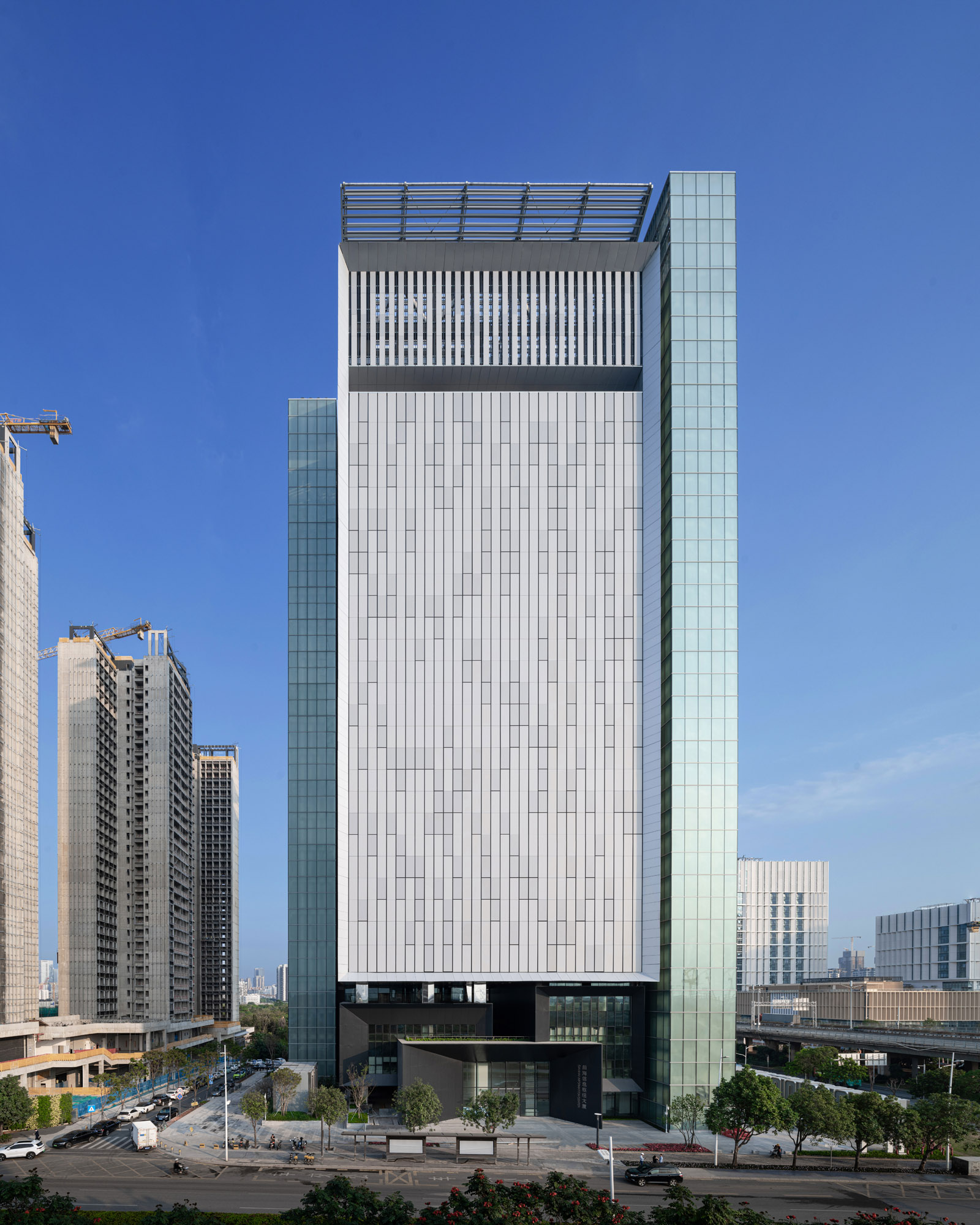 The completed Qianhai Telecommunication Center, a tall silver data-center tower beneath a clear blue sky in Shenzhen