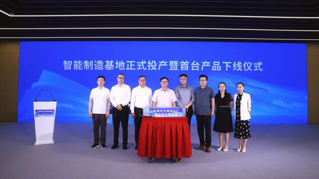 北京通州软通华方智能制造工厂投产仪式上，八人站在一台蒙着罩布的液冷服务器后方。