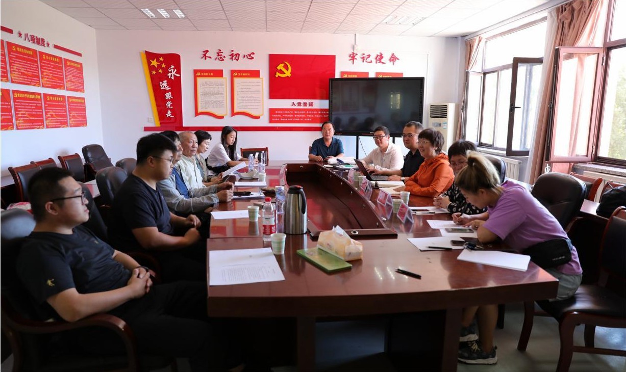 盘锦一次语言资源保护工作会议上，方言发音人与研究人员围坐在会议桌旁，桌上放着笔记本。