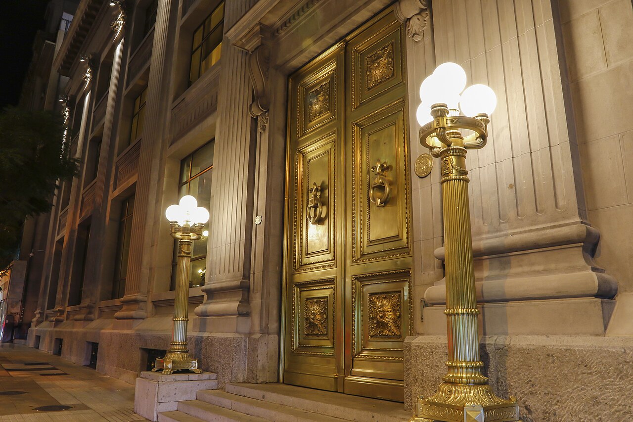 The illuminated stone facade of the Central Bank of Chile in Santiago.