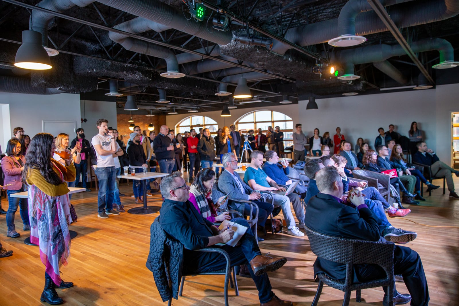 埃德蒙顿的Startup TNT Pitch Night活动现场，坐着和站着的与会者正在聆听演讲。