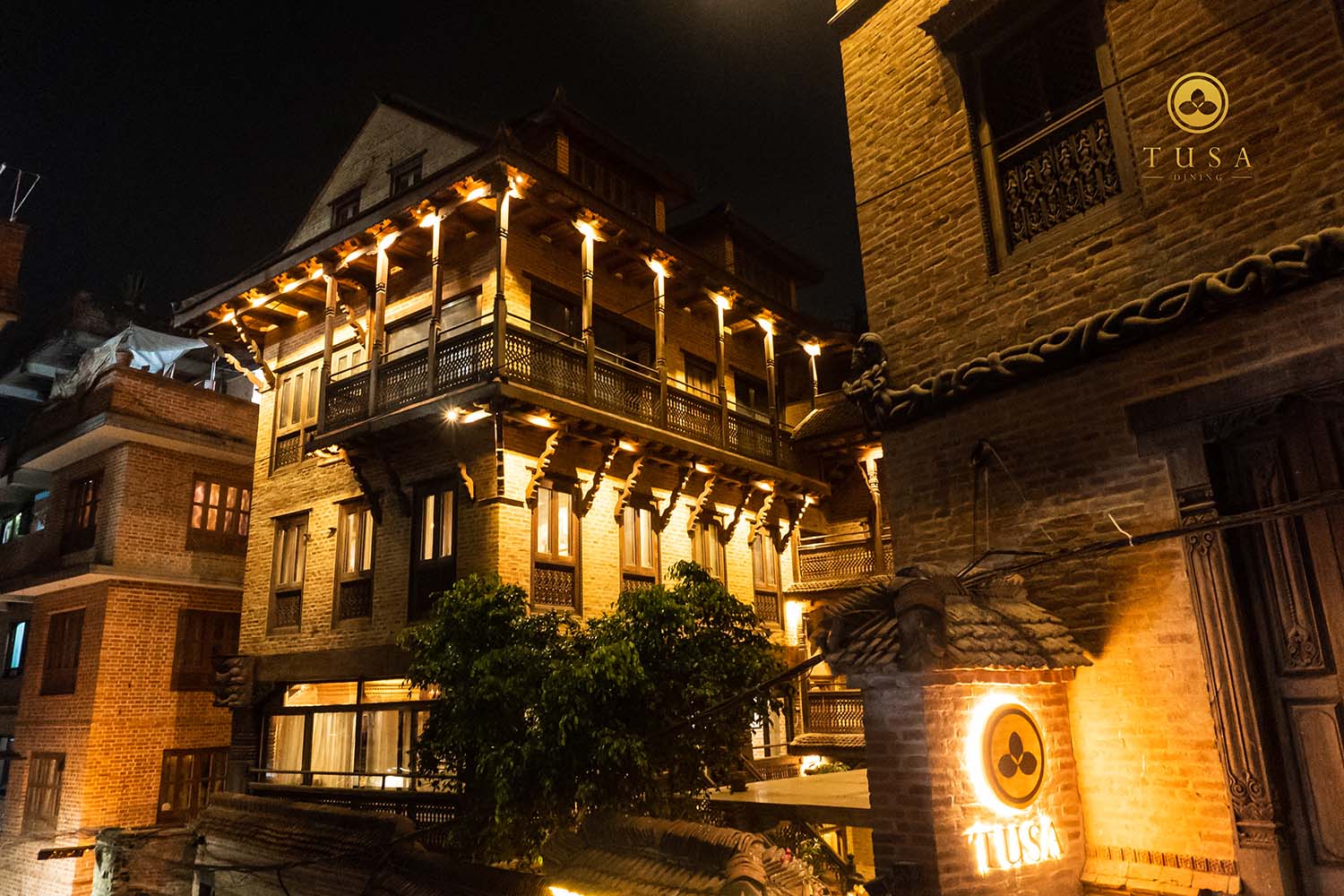 夜色中的巴克塔普尔，Tusa 餐厅灯火明亮，显出砖墙与木构外观。