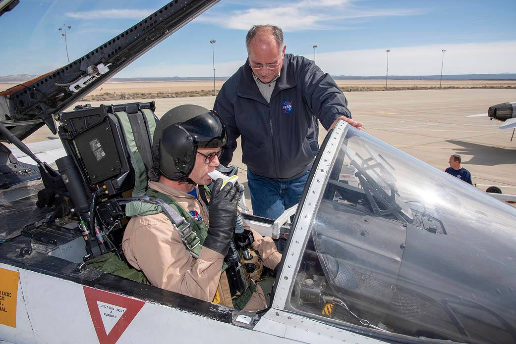 NASA pilot Nils Larsen uses a spirometer while Phillip Wellner monitors the test beside him.