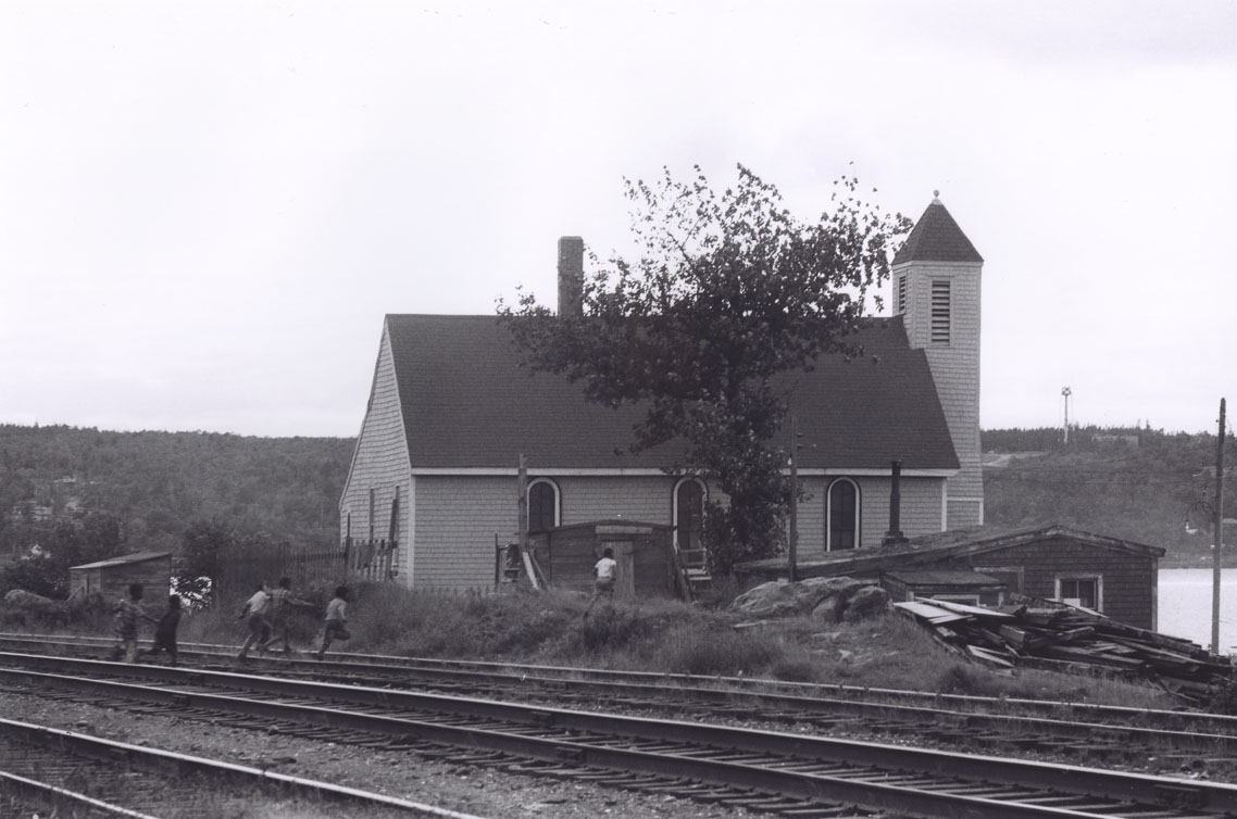 Boys crossing railway tracks toward the original Seaview African United Baptist Church in Africville.