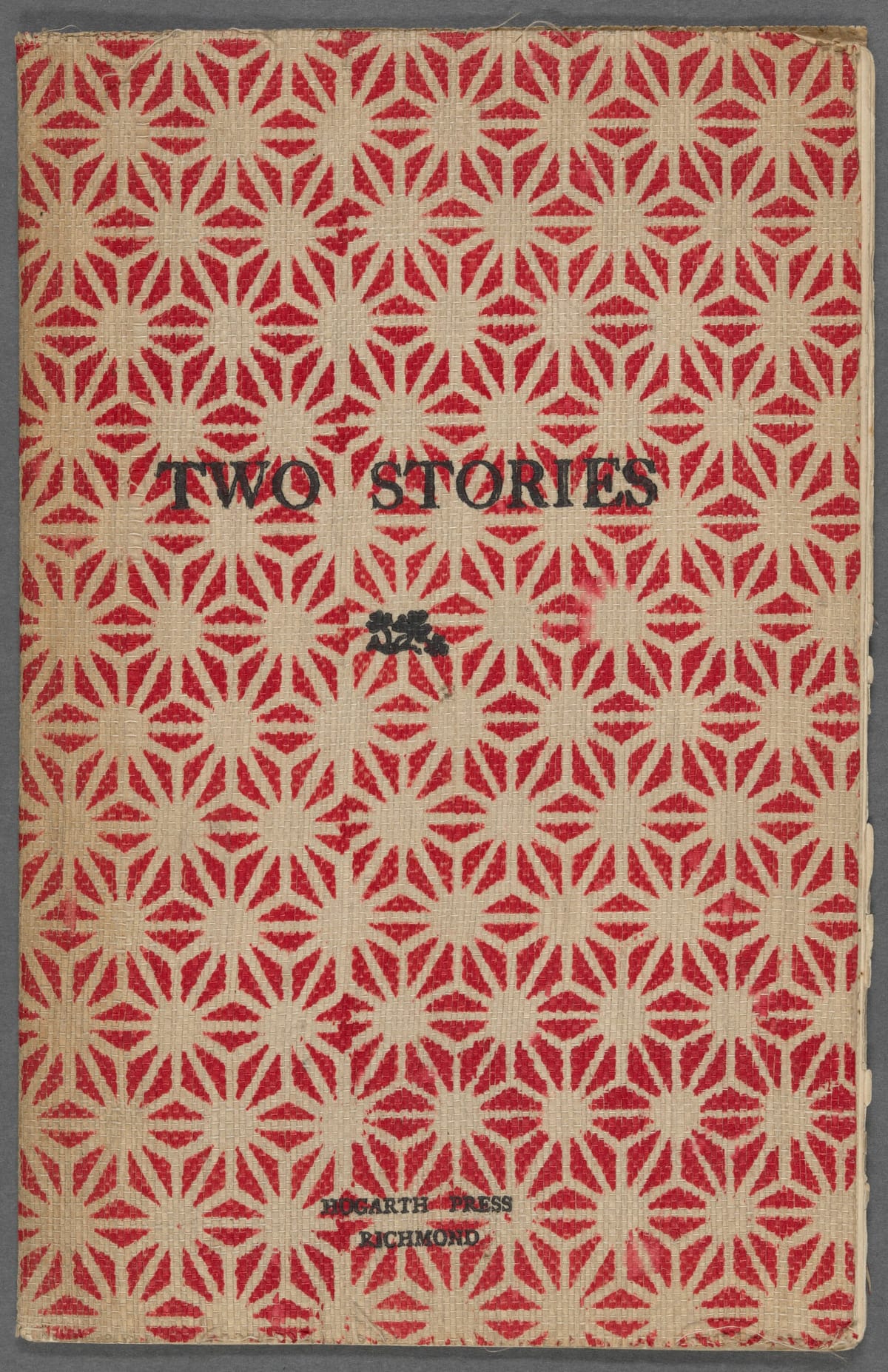 Worn red-and-cream patterned cover of the 1917 Hogarth Press first edition of Two Stories.