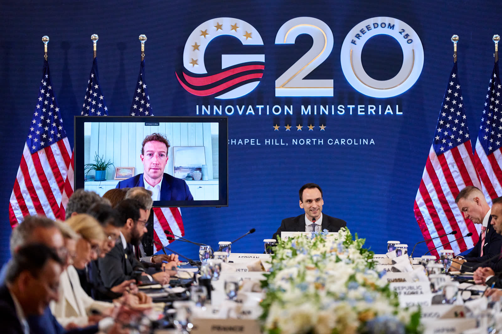 美国科学顾问迈克尔·克拉齐奥斯在 G20 创新部长级会议上发言，Meta 负责人马克·扎克伯格出现在会场的大屏幕上。