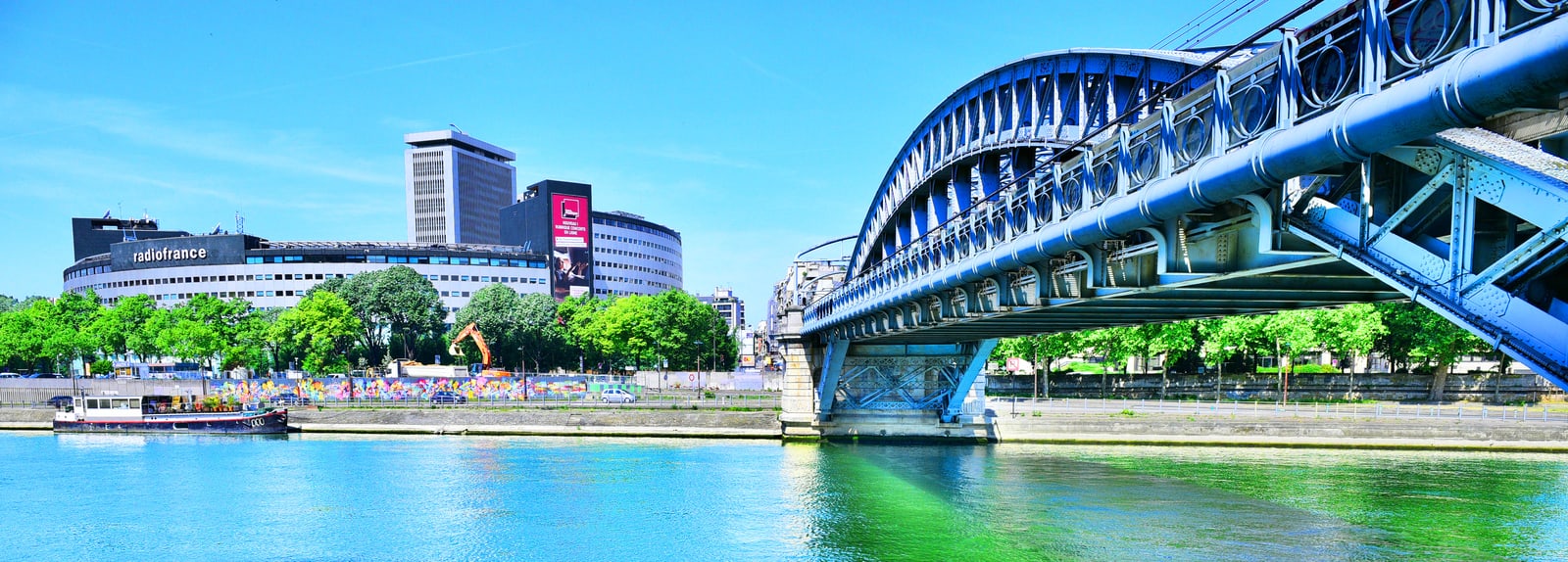 The circular Maison de la Radio beside the Seine in Paris, with the steel Pont Rouelle crossing the river in the foreground.