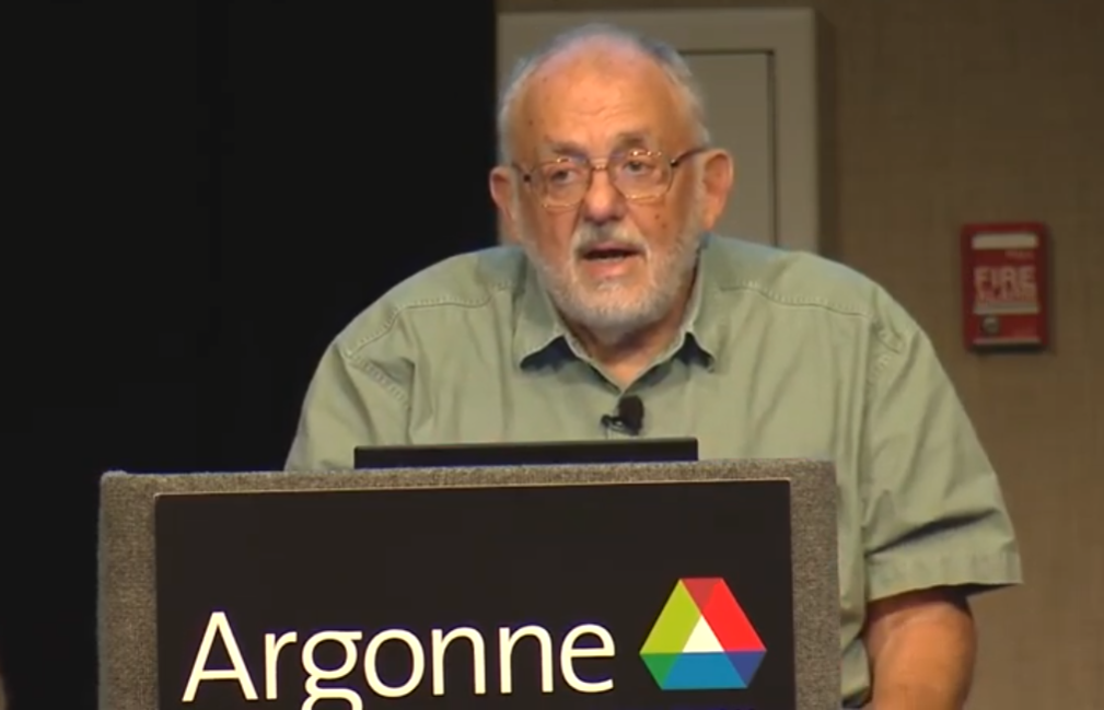 MATLAB creator Cleve Moler speaks at a seminar lectern beside a laptop and microphone.