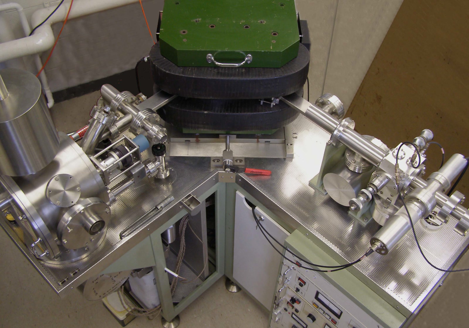 Photograph of a thermal ionization mass spectrometer in a geochronology laboratory, with its metal sample housing, gauges and electronic controls visible.