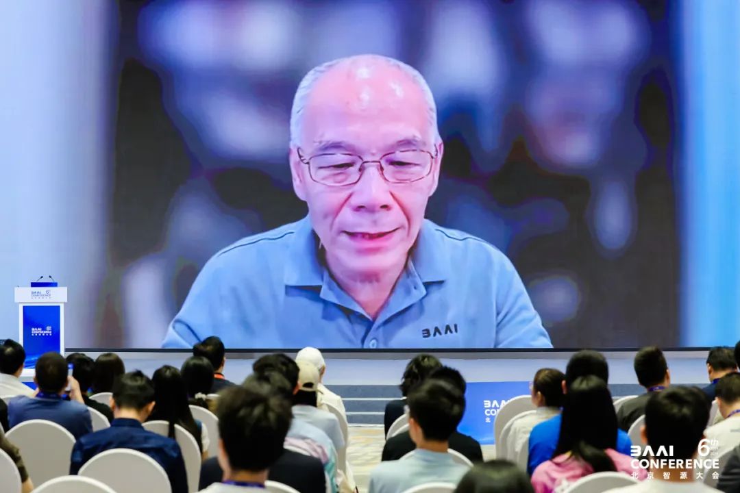 2024 智源大会上，观众面向大屏幕，观看张宏江的视频发言。