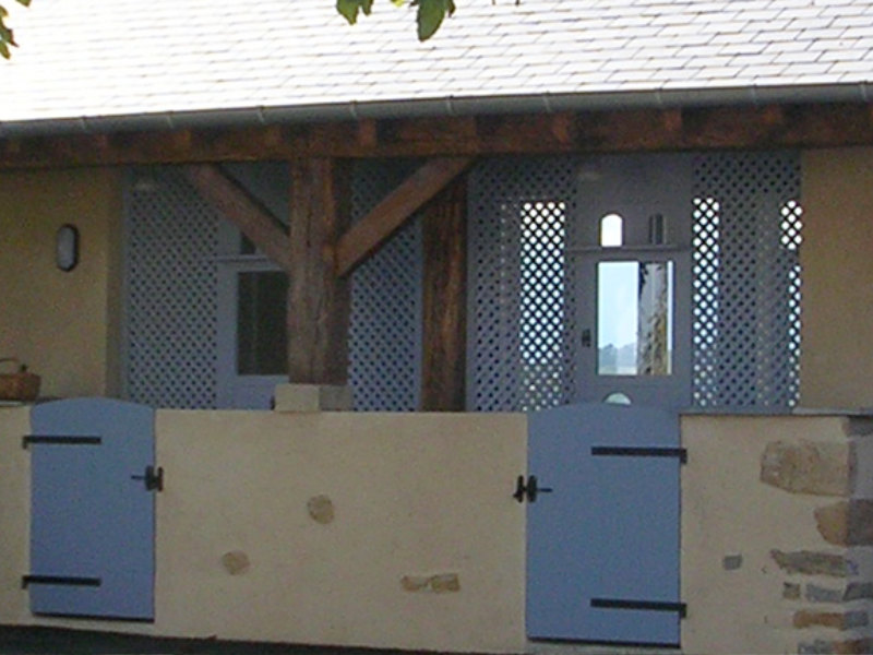 Blue half-doors and lattice shutters beneath a slate roof at Clos Lapeyre’s reception building.