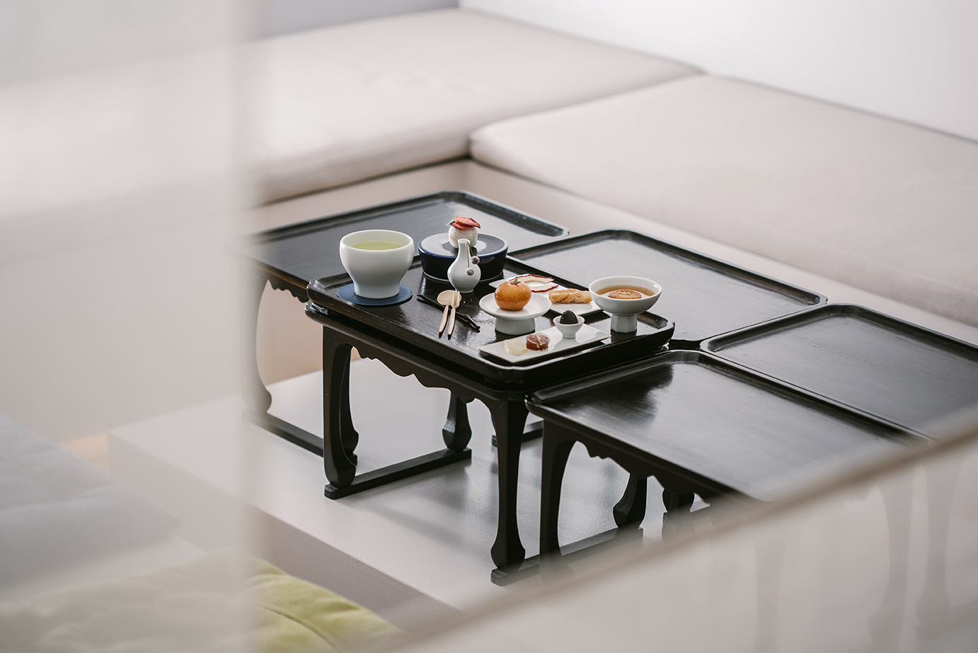 Korean sweets and tea arranged on a dark wooden soban at Kimssibooin in Seoul.