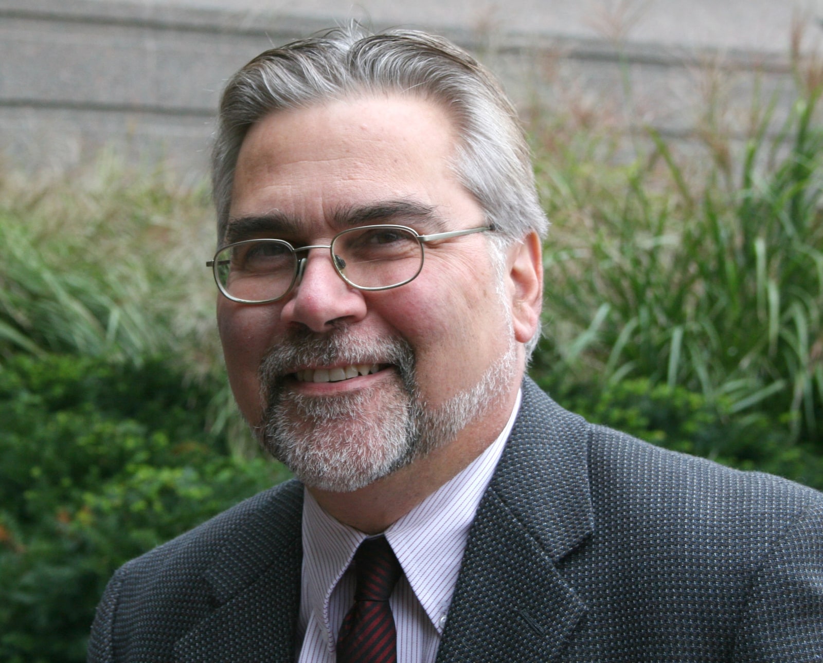 Demetrius Albanes, an ATBC investigator, photographed outdoors wearing a dark jacket and tie.
