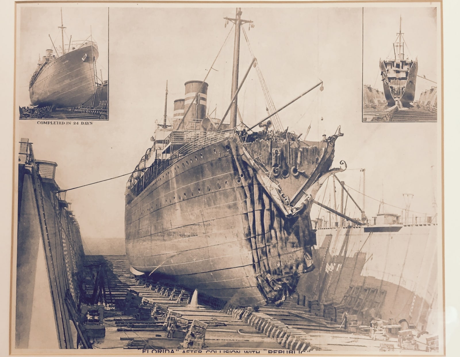 Archival photograph of Florida in dry dock, with her bow crushed inward and torn steel plates exposed above the dock floor.