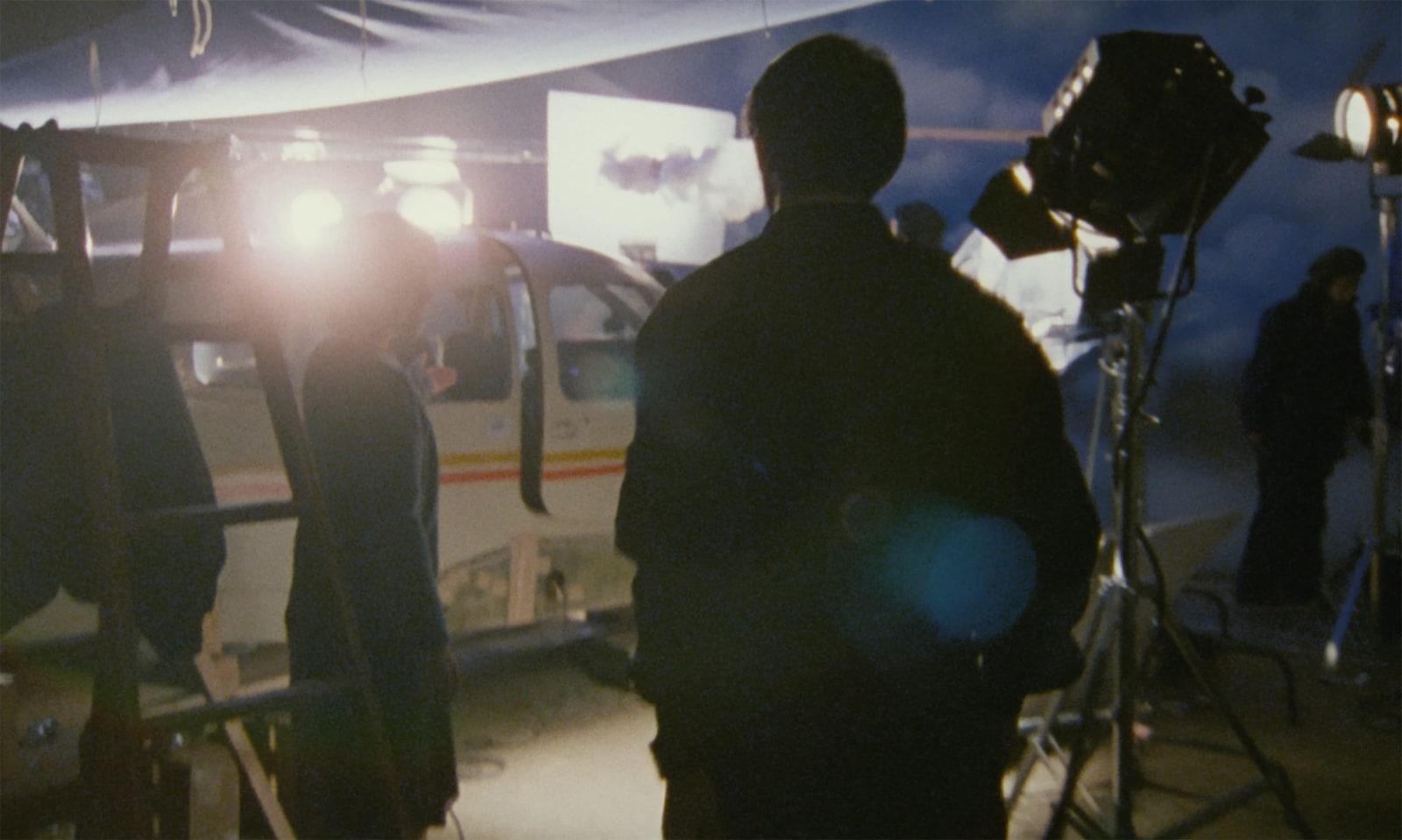 Crew members and studio lights surround an airplane cabin while filming a flight memory in After Life.