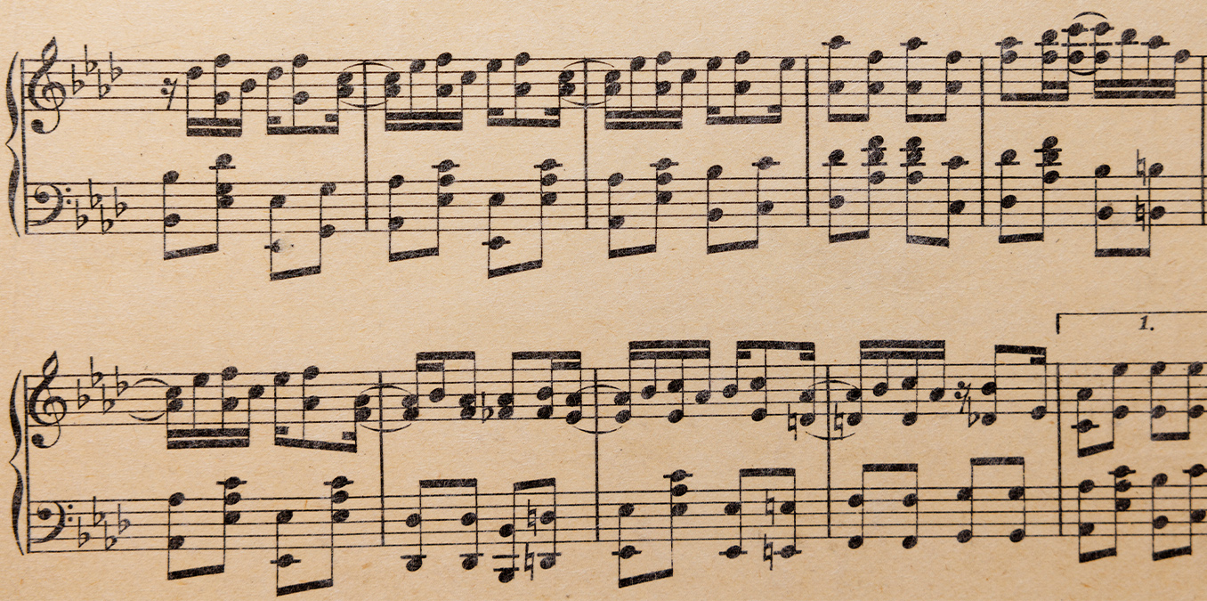Close photograph of aged sheet music from Maple Leaf Rag, with densely printed piano notes, beams, and curved ties across the staves.