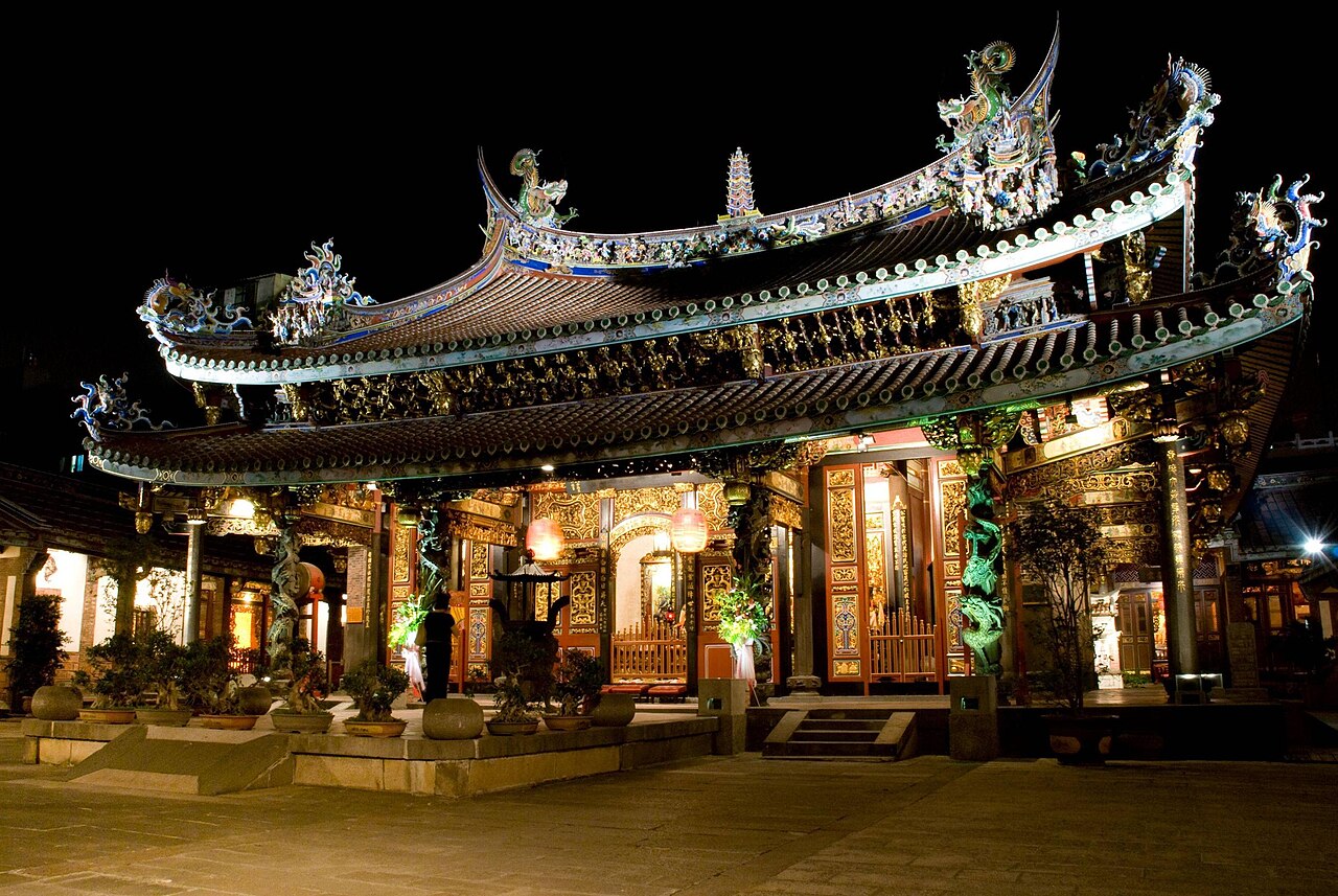 夜间灯光照亮台北保安宫，华丽的屋顶、入口与庭院清晰可见。