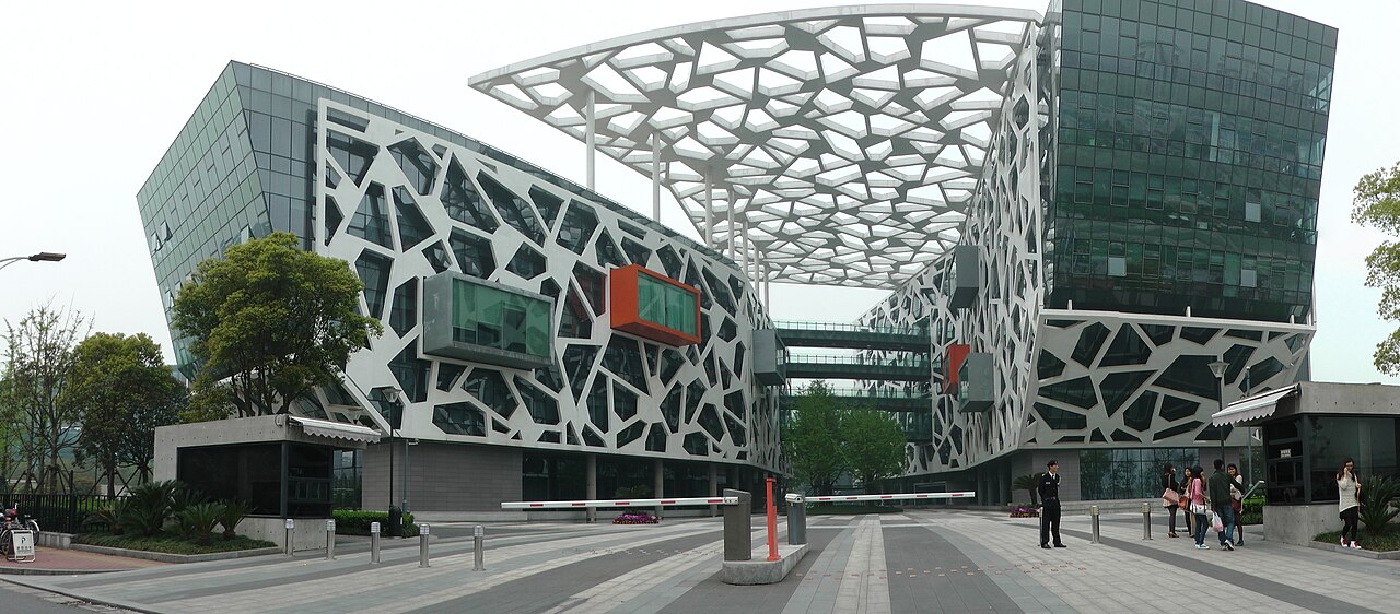 Alibaba Group headquarters in Hangzhou photographed from across a reflecting pool.