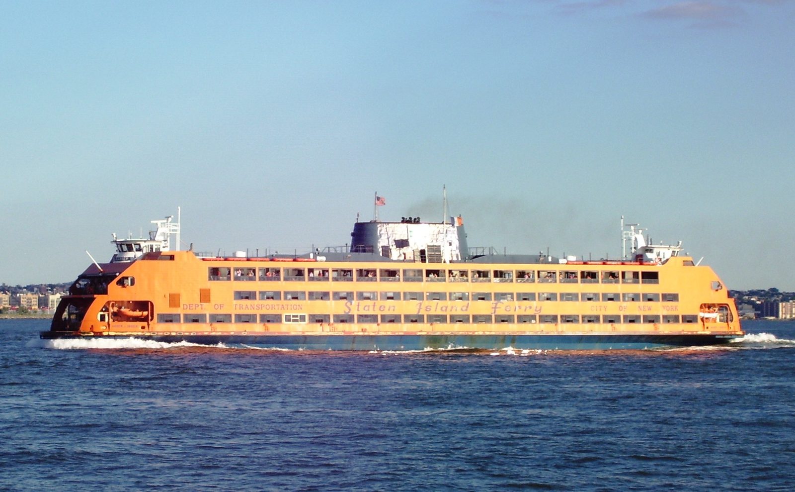 A Staten Island Ferry vessel crossing New York Harbor with lower Manhattan in view.