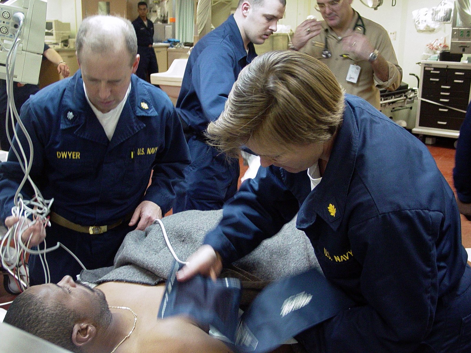 U.S. Navy doctor and nurse monitoring the vital signs of a rescued fisherman aboard a ship in 2003.