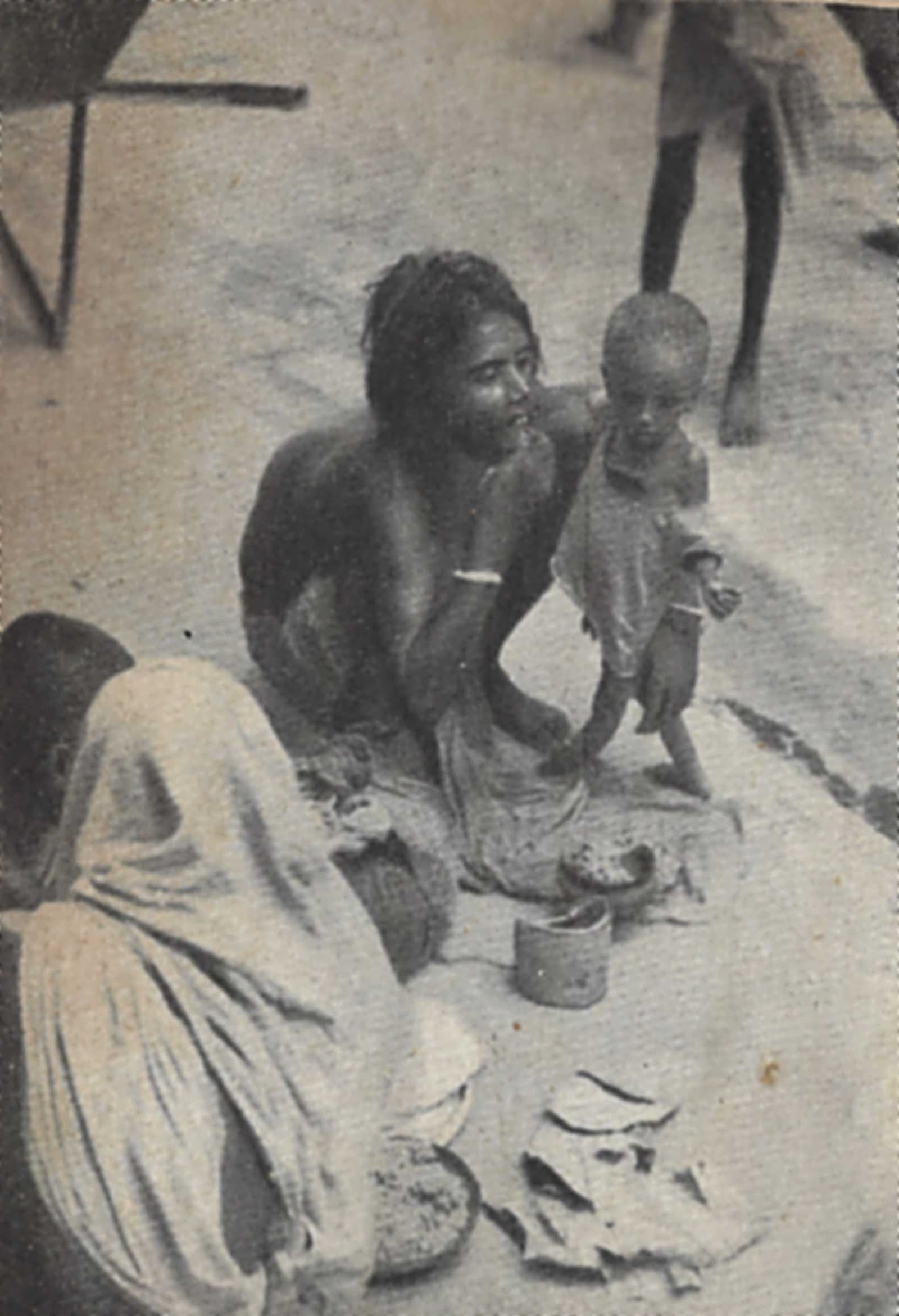 Archival photograph of a destitute mother and child on a Calcutta sidewalk during the Bengal famine.