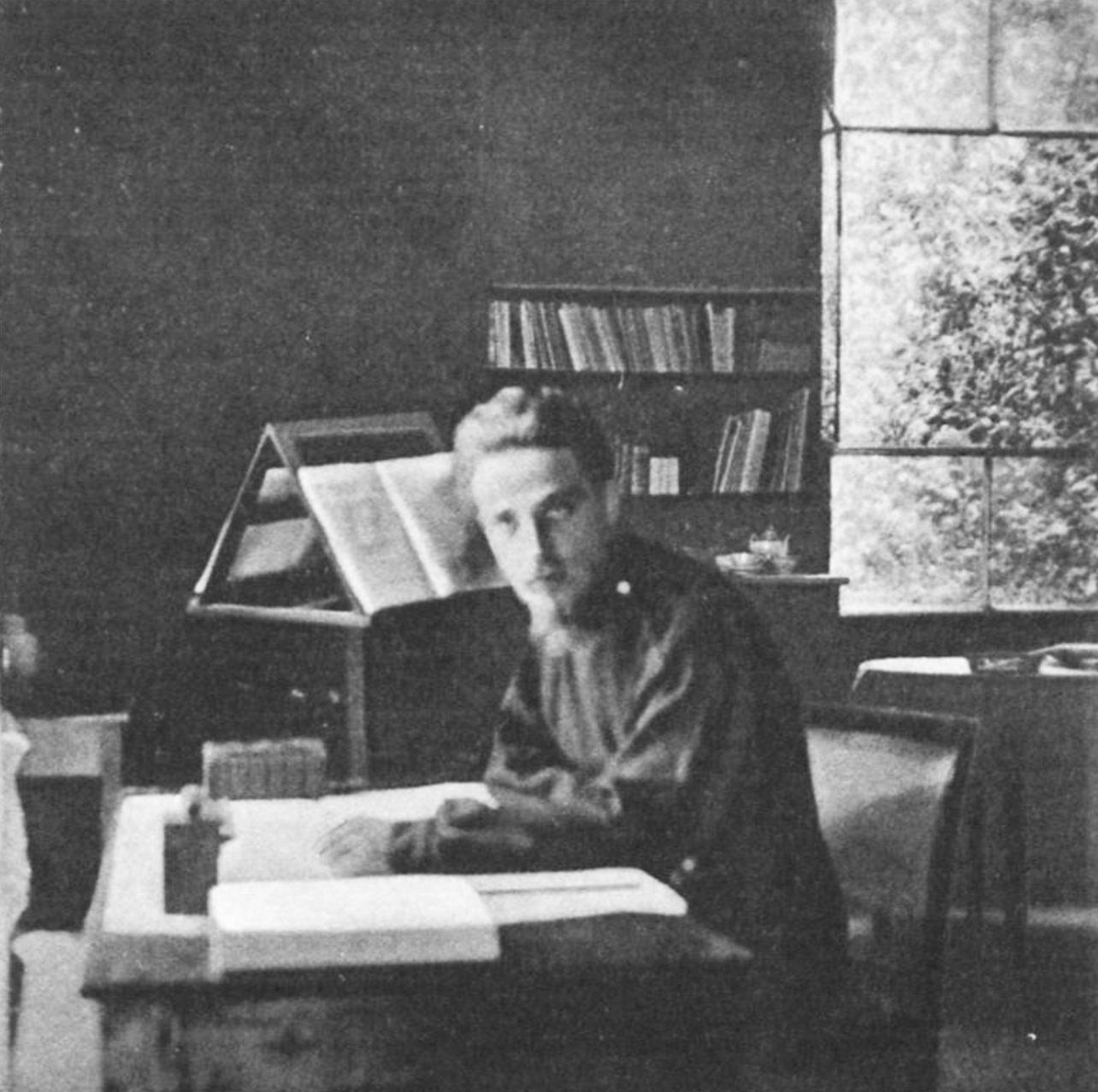 1904年，莱纳·玛利亚·里尔克坐在罗马工作室的书桌前，身边是书籍与纸张，一旁立着高窗。