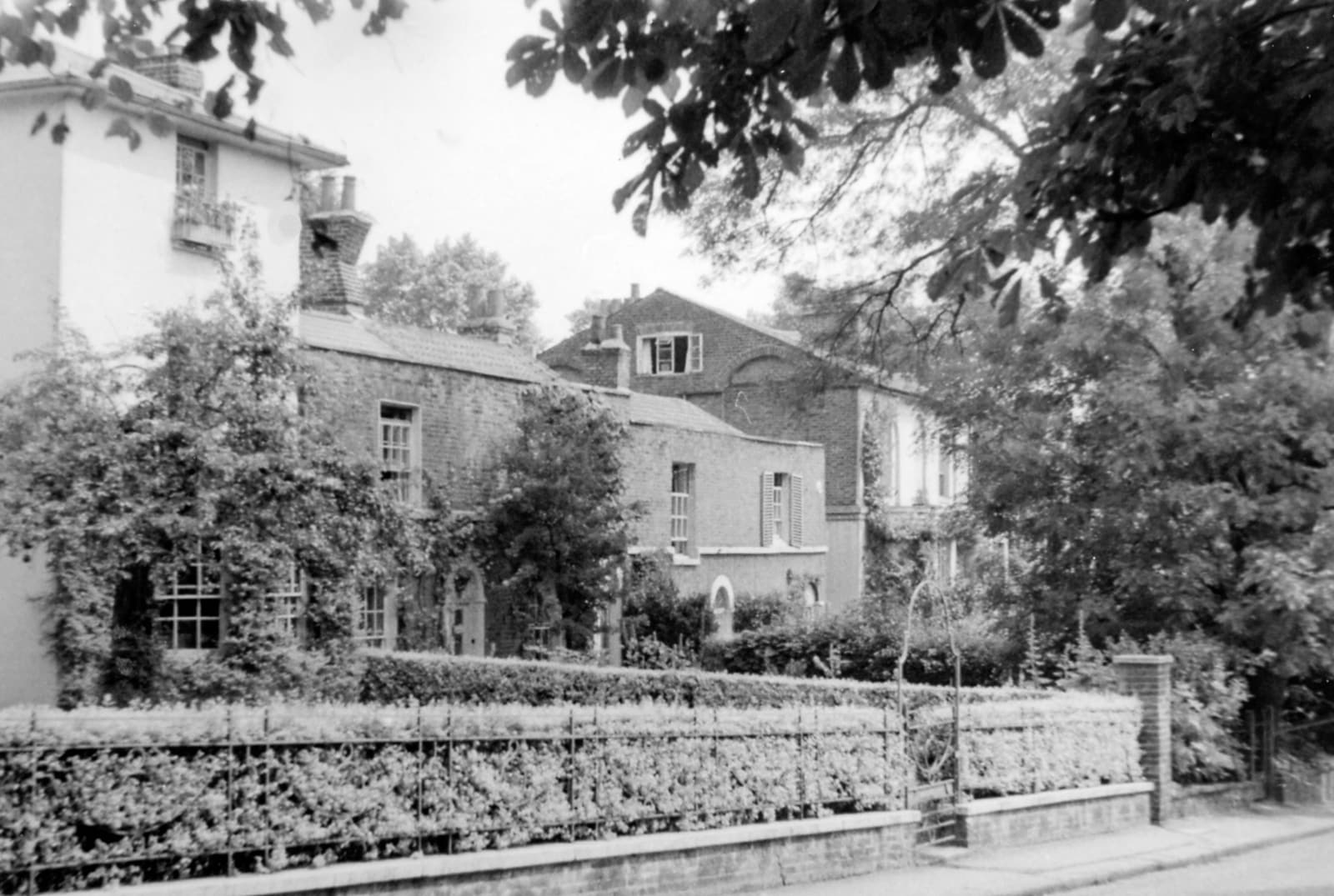 1955 年黑白照片，沿 Keats Grove 望向汉普斯特德的 Keats House。